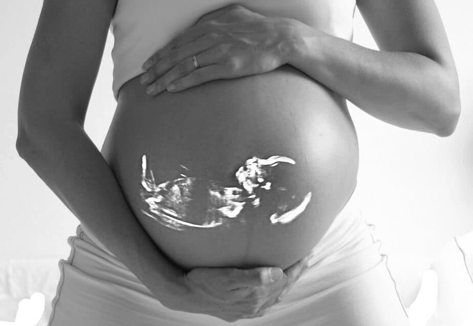 Zarys dziecka w łonie matki na tle kobiety w ciąży.