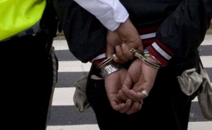Policja aresztuje osobę, założone kajdanki.