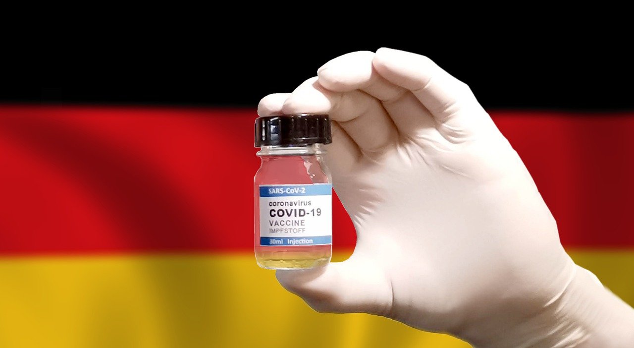 Szczepionka na koronawirusa na tle niemieckiej flagi.