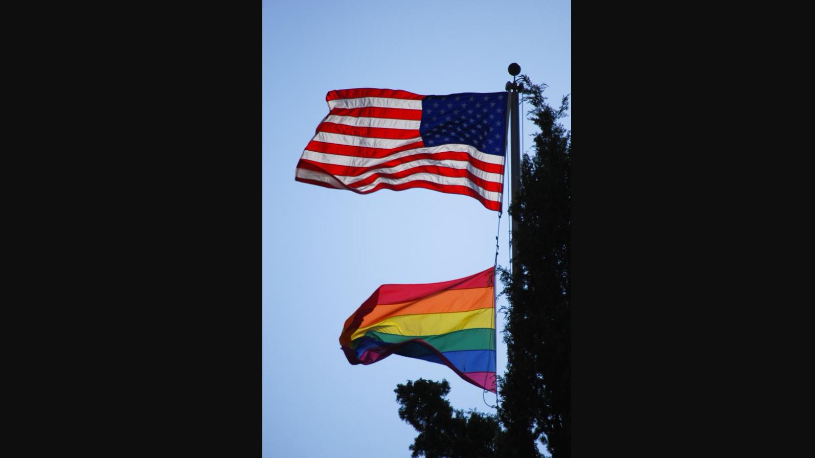 Flagi USA i LGBT na jednym maszcie