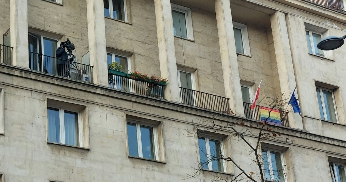 Kamera TVN i flaga LGBT na balkonach.