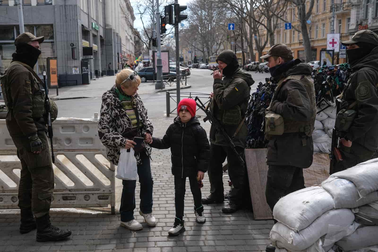 Ukraińscy żołnierze stoją obok barykady i sprawdzają paszporty w Odessie.
