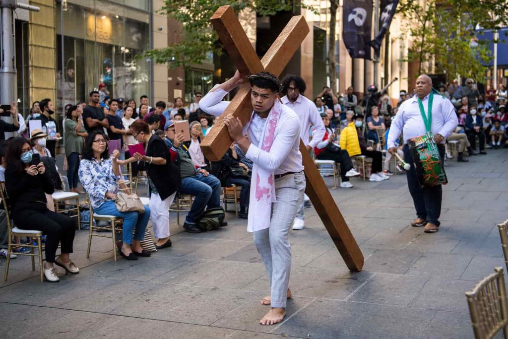 Loni Akauola, odtwórca roli Jezusa, niesie krzyż podczas wielkopiątkowego Marszu Ukrzyżowania w Sydney, Australia.